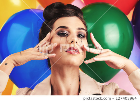 Face, beauty and makeup with a model woman in studio against a balloon background for fashion or style. Portrait, party and sad with an attractive young female posing with balloons at a birthday 127405964