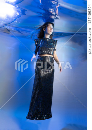 Girl in a Fabulous Mermaid Outfit Swims Gracefully Under the Shimmering Water 127406294