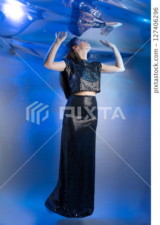 Fabulous Girl in a Shimmering Mermaid Outfit Swimming in Enchanting Blue Waters 127406296