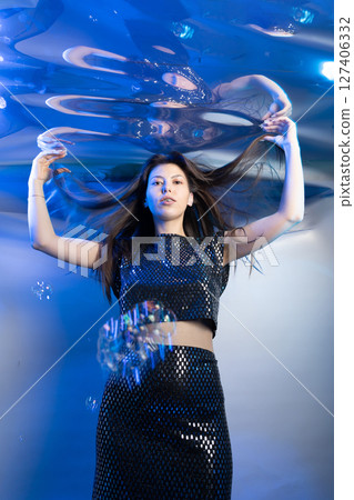 Mermaid Girl Gracefully Poses Underwater in a Fabulous Outfit Surrounded by Bubbles 127406332