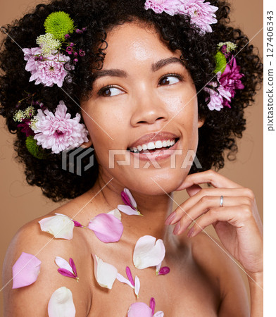 Beauty, makeup or black woman hair with flower portrait in brown studio background for skincare or luxury wellness with smile. Spring model, cosmetics or face of American girl with flowers for summer 127406343
