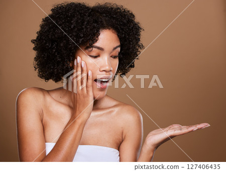 Skincare, girl and surprise hand product placement with wow, excited and healthy beauty face. Natural, facial and hair care of black woman in brown studio mockup for cosmetics advertising. Skincare, girl and surprise hand product placement with wow, excited and healthy beauty face. Natural, facial and hair care of black woman in brown studio mockup for cosmetics advertising. 127406435