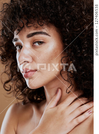 Skincare, hair care and face of a woman with makeup, beauty and natural glow against a brown studio background. Salon, luxury and portrait of a model with cosmetics and wellness care for afro hair Skincare, hair care and face of a woman with makeup, beauty and natural glow against a brown studio background. Salon, luxury and portrait of a model with cosmetics and wellness care for afro hair 127406538