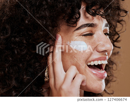 Cream, woman and skincare for wellness, natural beauty and confident on brown studio background. Cosmetics, female and girl with lotion, smooth face and organic facial with smile, happy and freckles. 127406674