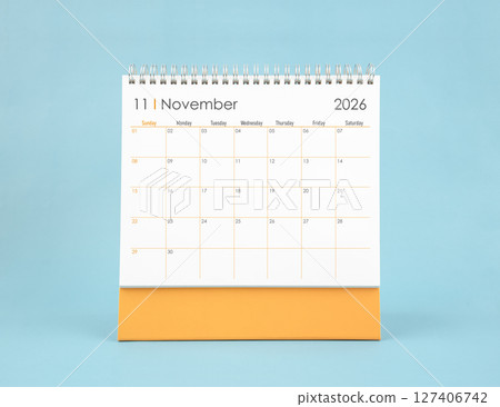 November 2026 white desk calendar on blue color background. Planning and goals concepts. November 2026 white desk calendar on blue color background. Planning and goals concepts. 127406742