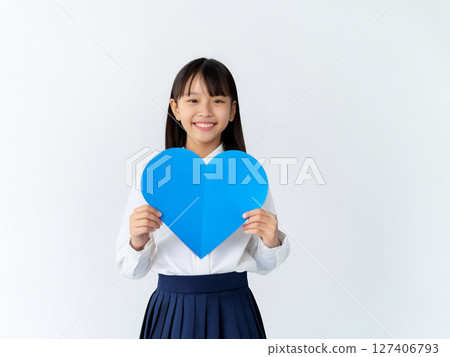 學生拿著一張藍色心形卡片 學生拿著一張藍色心形卡片 127406793