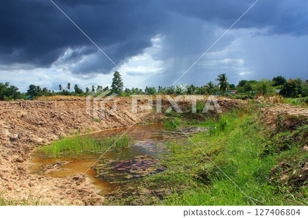 A newly dug well with a storm behind it 127406804