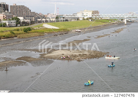 退潮後露出灘塗,人們在享受划船的樂趣(江戶川洩水道) 退潮後露出灘塗,人們在享受划船的樂趣(江戶川洩水道) 127407476