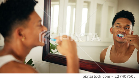 Home, man and dental with toothbrush in mirror, oral care and mouth treatment in morning routine. Reflection, male person and wellness with teeth whitening for gums, hygiene and grooming in bathroom 127407503