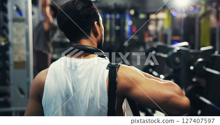 Back, exercise and man in gym, fitness and body workout with training, routine and commitment. Person, healthy and athlete in wellness center, bag and walking with practice, endurance and challenge 127407597