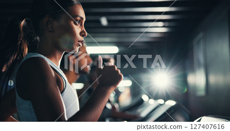 Fitness, girl and running on treadmill in gym at night for agility training, speed challenge and sports practice. Flare, evening workout or runner on machine for cardio exercise or muscle performance 127407616