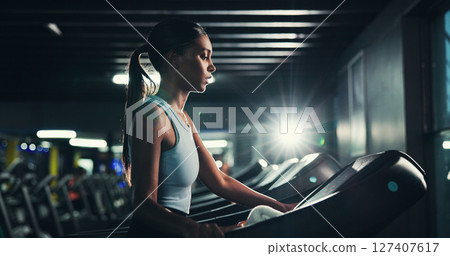 Fitness, profile and treadmill with woman in gym for cardio training or performance routine. Exercise, intense and running with Indian athlete in dark health club for break, challenge or workout Fitness, profile and treadmill with woman in gym for cardio training or performance routine. Exercise, intense and running with Indian athlete in dark health club for break, challenge or workout 127407617