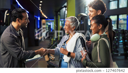 Man, woman and handshake with welcome at gym for class, registration and tablet with exercise group. Mature person, personal trainer and touchscreen for respect, app or introduction at fitness center Man, woman and handshake with welcome at gym for class, registration and tablet with exercise group. Mature person, personal trainer and touchscreen for respect, app or introduction at fitness center 127407642