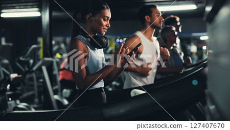 Runner, phone and music with woman on treadmill for workout playlist, training app and health. Gym membership, exercise and progress check with person on running machine for radio and sports Runner, phone and music with woman on treadmill for workout playlist, training app and health. Gym membership, exercise and progress check with person on running machine for radio and sports 127407670