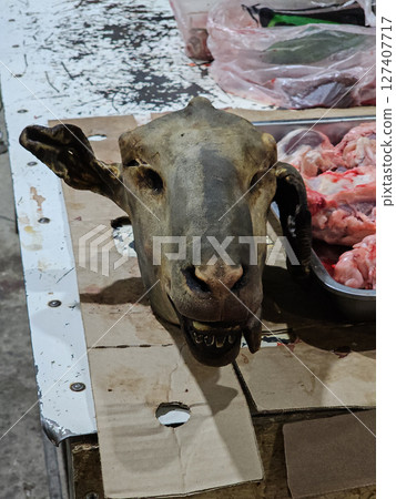 Sheep head and butchered meat pieces at market stall in Kyrgyzstan Sheep head and butchered meat pieces at market stall in Kyrgyzstan 127407717