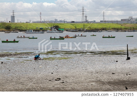 Tidal flats revealed by low tide and people enjoying boating (Edogawa Floodway) Tidal flats revealed by low tide and people enjoying boating (Edogawa Floodway) 127407955