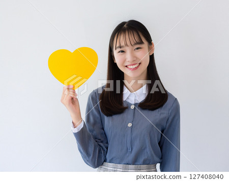 Student holding a yellow heart card 127408040
