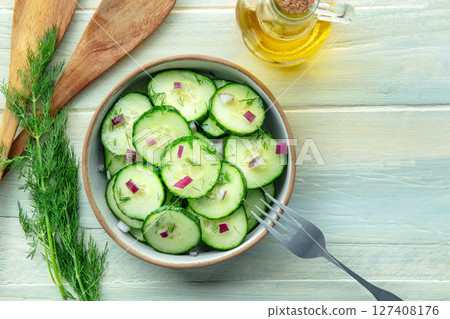 Cucumber salad with dill and red onion, overhead flat lay shot on a rustic table 127408176