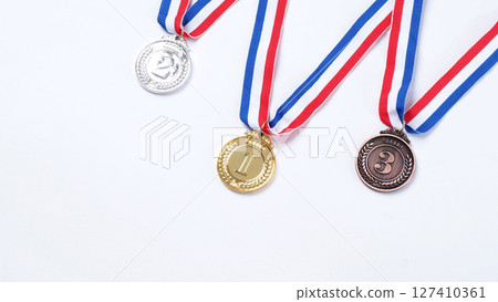 Gold silver and bronze demonstration trophy medals with ribbon for school university or national or olympic sport even organization competition. Isolated on white background. Award and victory concept Gold silver and bronze demonstration trophy medals with ribbon for school university or national or olympic sport even organization competition. Isolated on white background. Award and victory concept 127410361