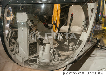 A close-up of a helicopter cockpit interior showing control panels, levers, and flight instruments. The image captures the technical complexity and historic aviation design. 127410832