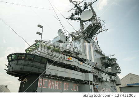 Close-up view of the command tower and radar antennas aboard the USS Intrepid aircraft carrier. The image showcases complex naval architecture and warning signs like BEWARE OF JET. Close-up view of the command tower and radar antennas aboard the USS Intrepid aircraft carrier. The image showcases complex naval architecture and warning signs like BEWARE OF JET. 127411003