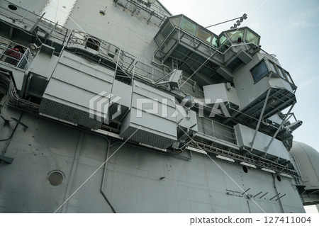 Close-up view of the USS Intrepid exterior showing angular platforms, technical compartments, and communication elements. The ship's structural complexity highlights its historical role in naval Close-up view of the USS Intrepid exterior showing angular platforms, technical compartments, and communication elements. The ship's structural complexity highlights its historical role in naval 127411004