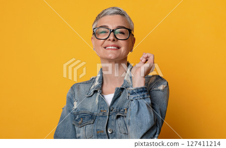 Eyewear Fashion. Happy Middle-Aged Woman Posing In Stylish Eyeglasses Over Yellow Background, Looking At Camera And Smiling, Copy Space Eyewear Fashion. Happy Middle-Aged Woman Posing In Stylish Eyeglasses Over Yellow Background, Looking At Camera And Smiling, Copy Space 127411214