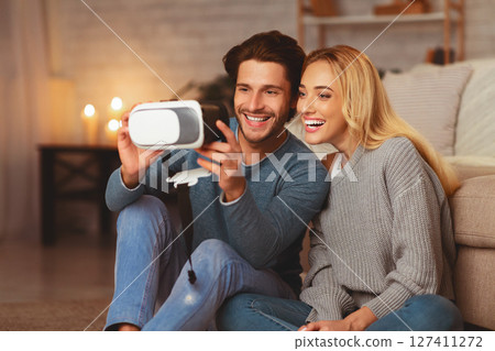 Excited Couple Trying Virtual Reality Glasses Having Fun At Home In The Evening. Selective Focus Excited Couple Trying Virtual Reality Glasses Having Fun At Home In The Evening. Selective Focus 127411272