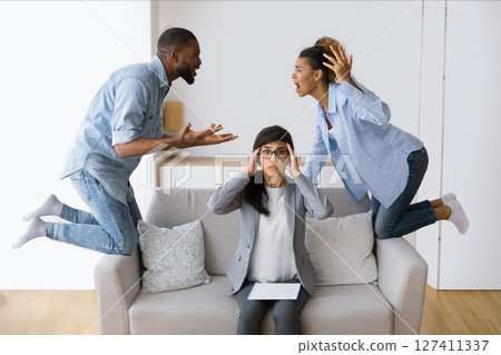 Marriage Crisis. Overwhelmed Psychologist Watching Her Afro Patients Quarrelling In Office. Selective Focus 127411337