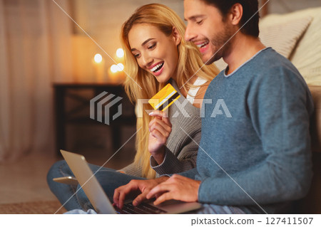 Online Shopping. Man And Woman Holding Laptop And Credit Card Purchasing Stuff On Internet Indoor. Selective Focus 127411507