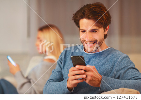 Cheating. Unfaithful Boyfriend Chatting On Phone Sitting With Girlfriend On Sofa At Home In Evening. Selective Focus Cheating. Unfaithful Boyfriend Chatting On Phone Sitting With Girlfriend On Sofa At Home In Evening. Selective Focus 127411573