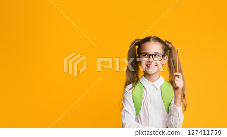 Eureka. Smiling Schoolgirl Pointing Pencil Up Having Idea Posing On Yellow Studio Background. Panorama, Empty Space 127411759