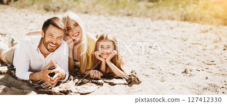 Family Picnic. Parents And Daughter Lying On Blanket Smiling To Camera On Summer Day Outdoors After End Of Quarantine. 127412330