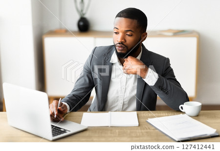 Portrait of confident black businessman in formal suit working in modern office interior, selective focus on man Portrait of confident black businessman in formal suit working in modern office interior, selective focus on man 127412441