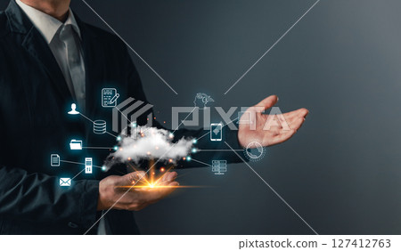 A hand holds a cloud computing icon, symbol data storage, secure backup, and management for uploading, downloading, and transfer files in a connected digital network and internet service environment. 127412763