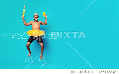 Summer vacation concept. Happy african american guy in swimwear and inflatable ring jumping with water guns like floating in water, drawn waves and flippers, copy space 127412852