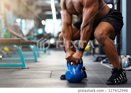 Cropped of black muscular man hands lifting kettlebell in empty gym. Unrecognizable african american guy bodybuilder building up muscles with iron ball, powerlifting concept, copy space 127412946