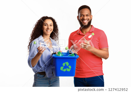 Recycling And Waste Sorting. Diverse Couple Holding Box With Recycle Symbol And Used Plastic Bottles Standing Over White Studio Background. Junk Disposal Concept Recycling And Waste Sorting. Diverse Couple Holding Box With Recycle Symbol And Used Plastic Bottles Standing Over White Studio Background. Junk Disposal Concept 127412952
