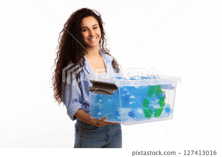 Smiling Lady Holding Box With Recycle Symbol Full Of Litter And Used Plastic Bottles Standing Over White Studio Background. Junk Sorting And Disposal, Waste Recycling Concept Smiling Lady Holding Box With Recycle Symbol Full Of Litter And Used Plastic Bottles Standing Over White Studio Background. Junk Sorting And Disposal, Waste Recycling Concept 127413016