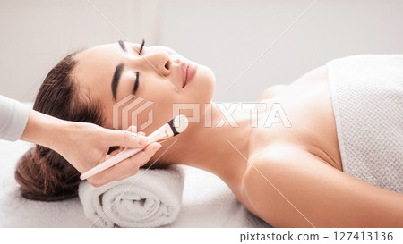 Skin Treatments. Young Korean Lady Enjoying Beauty Procedures In Spa Salon, Lying On Massage Table With Closed Eyes. Professional Beautician Applying Clay Mask To Attractive Asian Woman, Side View Skin Treatments. Young Korean Lady Enjoying Beauty Procedures In Spa Salon, Lying On Massage Table With Closed Eyes. Professional Beautician Applying Clay Mask To Attractive Asian Woman, Side View 127413136