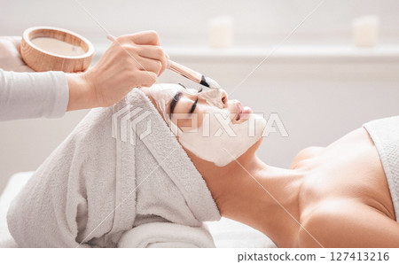 Young Korean Woman Enjoying Beauty Treatments In Spa Salon, Getting Nourishing Clay Mask On Face, Having Wellness Skin Procedures With Professional Cosmetologist, Side View, Closeup With Free Space Young Korean Woman Enjoying Beauty Treatments In Spa Salon, Getting Nourishing Clay Mask On Face, Having Wellness Skin Procedures With Professional Cosmetologist, Side View, Closeup With Free Space 127413216