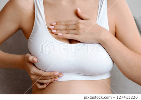Breast Diseases During Pregnancy. Unrecognizable Pregnant Lady In Top Bra Massaging Chest Area While Sitting On Couch At Home, Expectant Lady Suffering Body Changes While Expecting Baby, Cropped 127413220