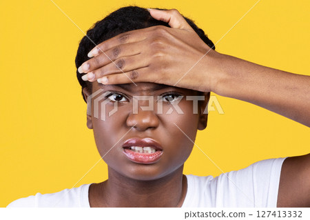 Fever Symptom. Unhappy African American Young Woman Touching Forehead Looking At Camera Standing Over Yellow Studio Background. Influenza And Coronavirus Covid-19 Symptoms Concept Fever Symptom. Unhappy African American Young Woman Touching Forehead Looking At Camera Standing Over Yellow Studio Background. Influenza And Coronavirus Covid-19 Symptoms Concept 127413332