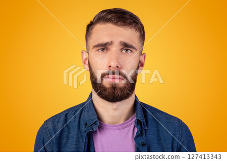 Millennial hipster guy feeling sad, lonely or depressed on grey studio background. Melancholic bearded man with unhappy face expression having trouble, suffering from stress or personal crisis Millennial hipster guy feeling sad, lonely or depressed on grey studio background. Melancholic bearded man with unhappy face expression having trouble, suffering from stress or personal crisis 127413343