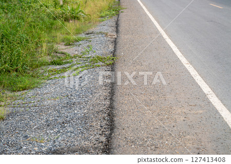 Roadside nature scene with gravel and greenery rural landscape outdoor natural view 127413408