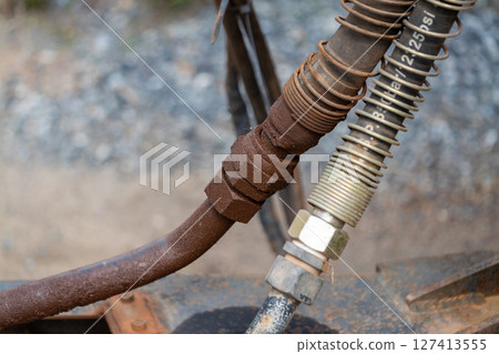 Industrial equipment maintenance hydraulic hose connection workshop close-up mechanical system 127413555