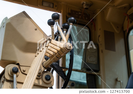 Construction equipment operators control heavy machinery at job site industrial environment close-up view 127413700
