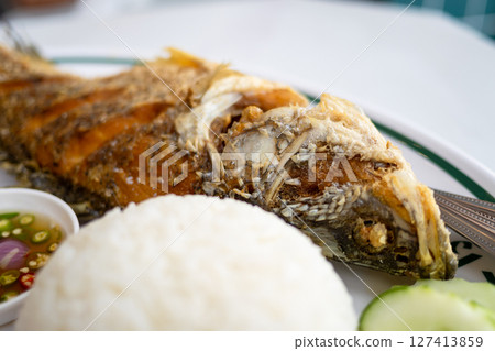 Crispy fried fish dish coastal restaurant food vibrant setting close-up angle Crispy fried fish dish coastal restaurant food vibrant setting close-up angle 127413859
