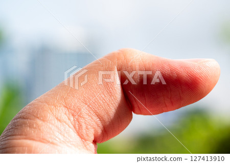 Focused view of hand gesture with thumb in nature expressing outdoor emotions 127413910