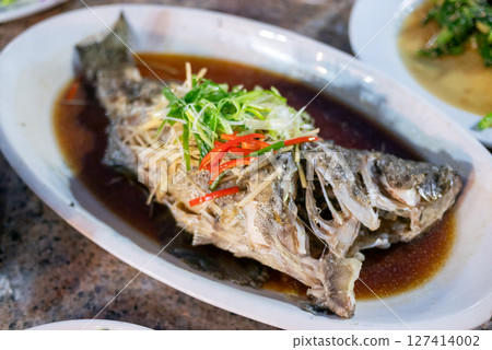 Delicious steamed fish dish local restaurant culinary delight cozy atmosphere close-up view seafood experience 127414002